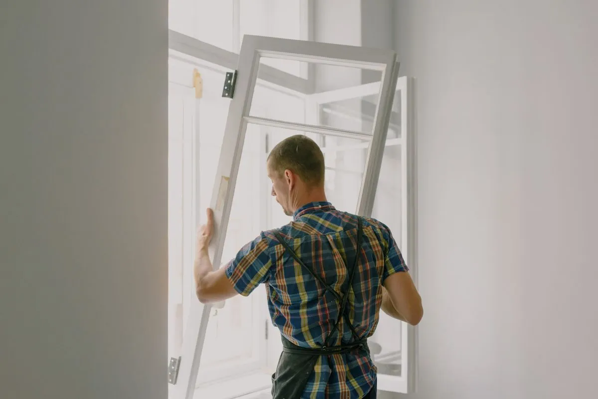 Profissional instalando vidro em residência durante reforma